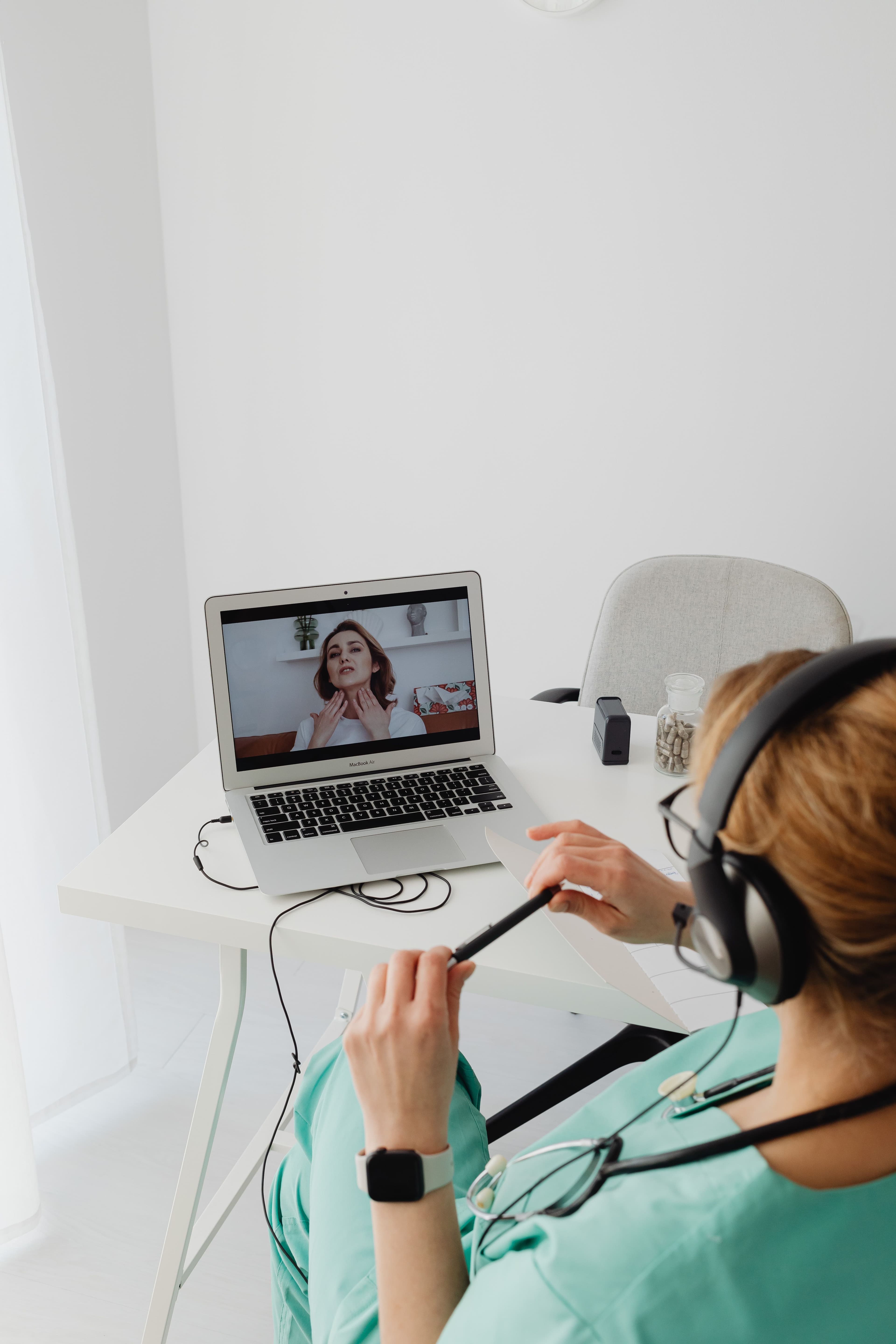 Clinician conducting a telehealth video consultation on a laptop