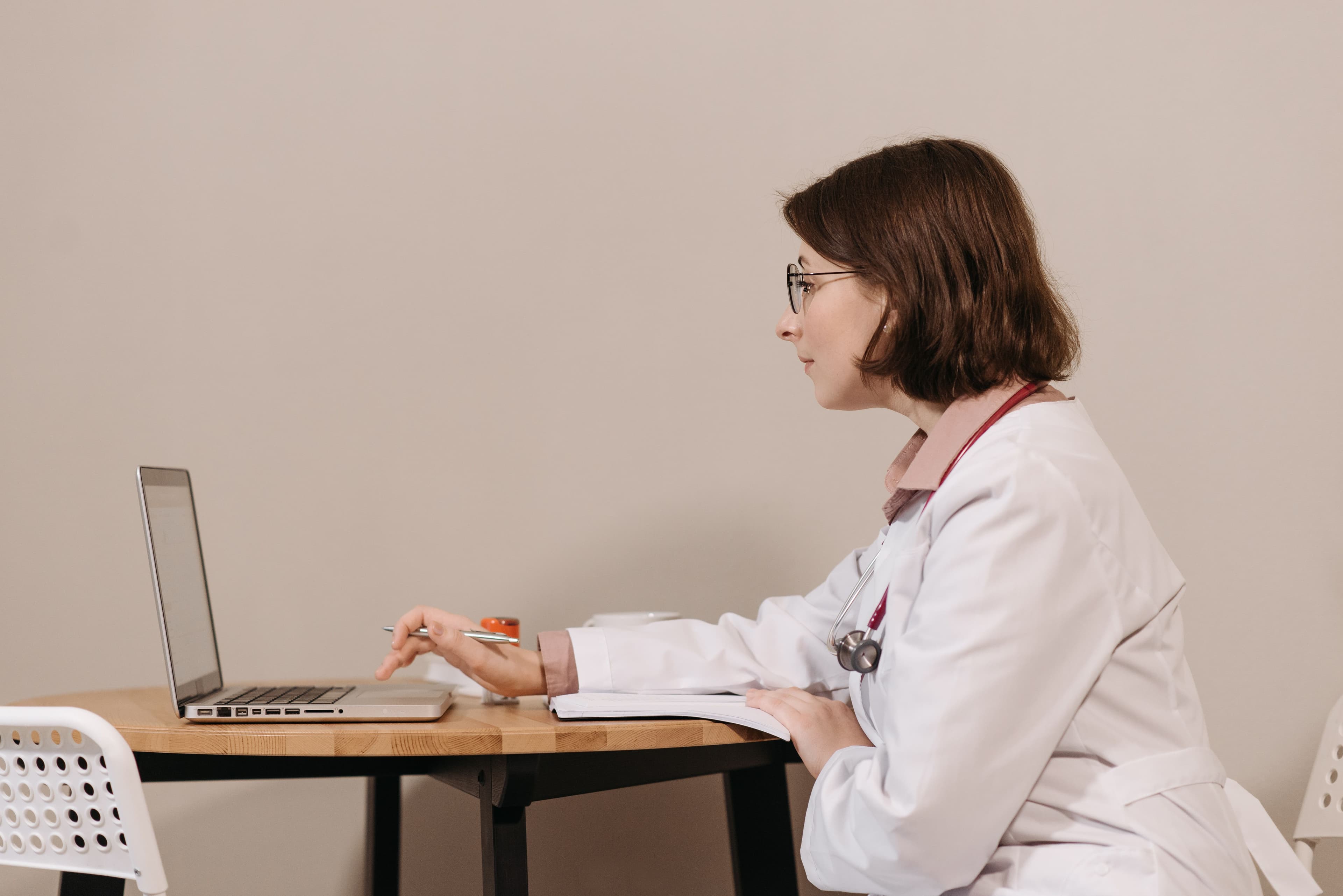 Clinician reviewing patient records on a laptop