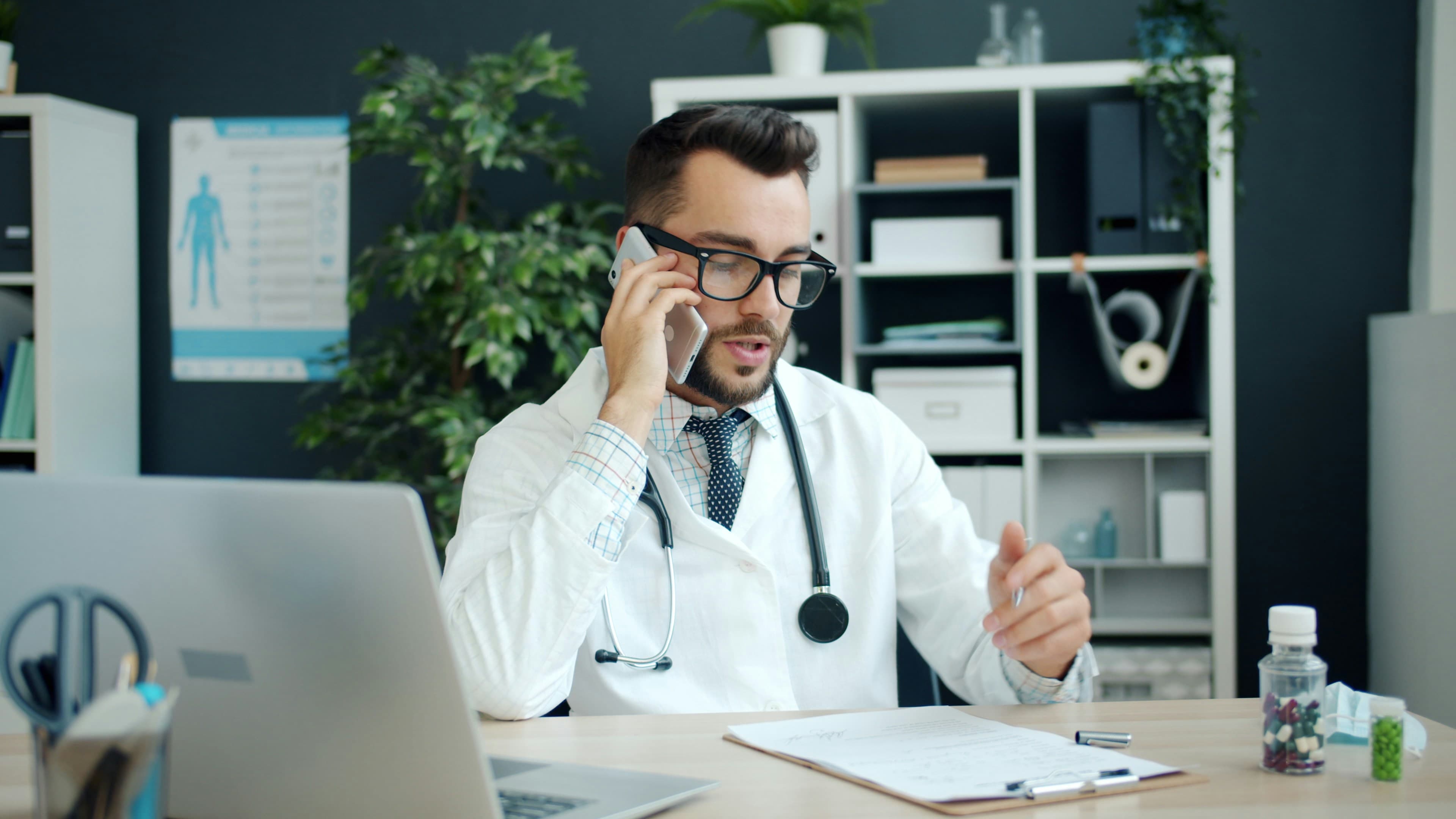 Doctor on a phone call with a patient at his desk